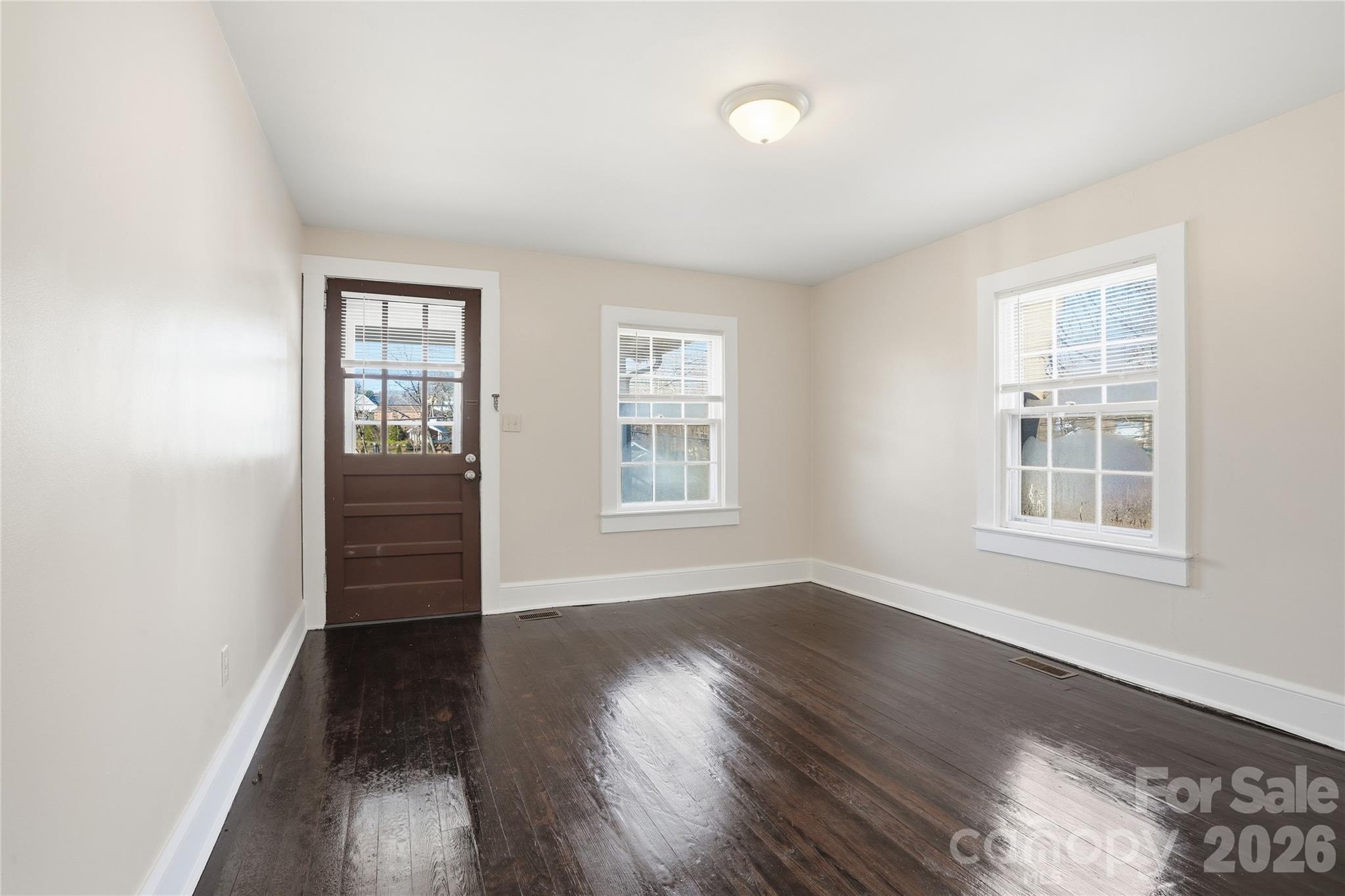 358 North Cleghorn Street Rutherfordton, NC 28139 - Photo 5 of 21 an empty room with wooden floor and windows