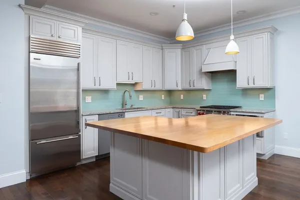 a kitchen with a sink a refrigerator and cabinets