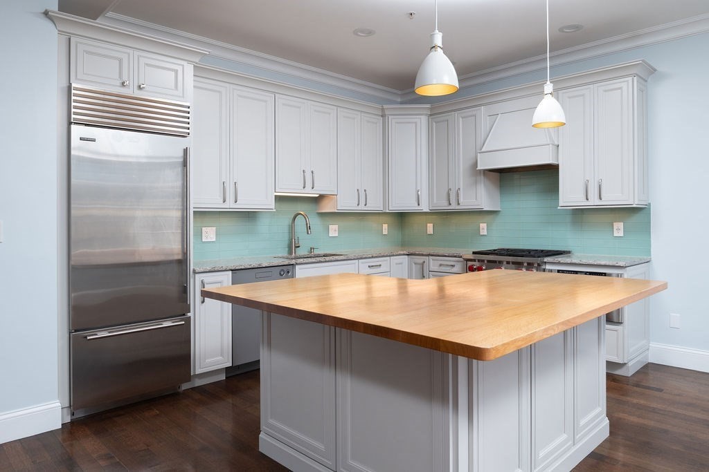 142 Fuller Street, Unit 4 Brookline, MA 02446 - Photo 1 of 40 a kitchen with a sink a refrigerator and cabinets