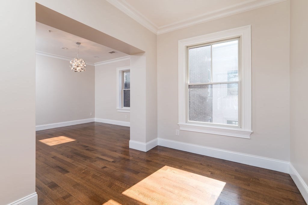 142 Fuller Street, Unit 4 Brookline, MA 02446 - Photo 11 of 40 an empty room with wooden floor and windows