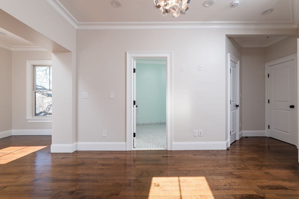 142 Fuller Street, Unit 4 Brookline, MA 02446 - Photo 12 of 40 an empty room with wooden floor and window