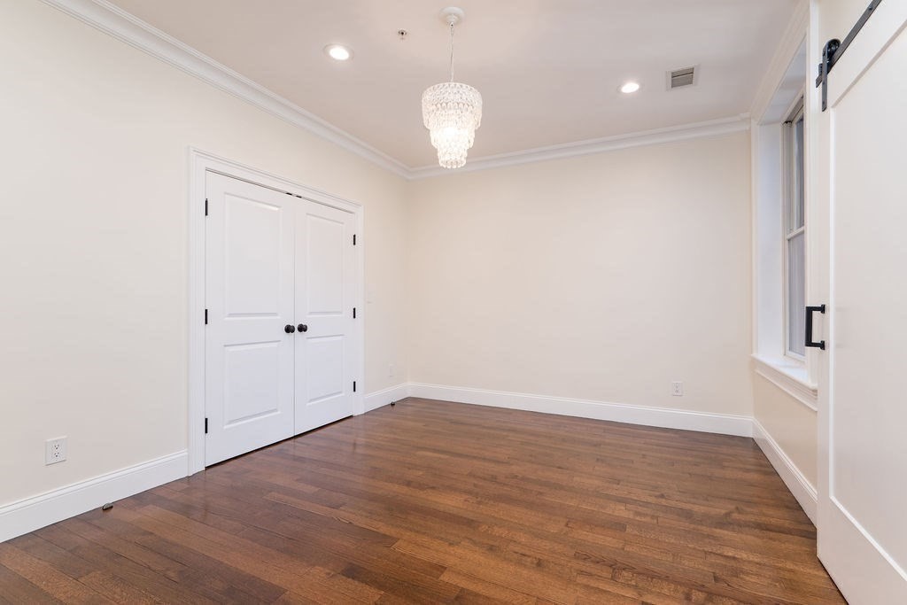 142 Fuller Street, Unit 4 Brookline, MA 02446 - Photo 23 of 40 a view of an empty room with wooden floor and a window