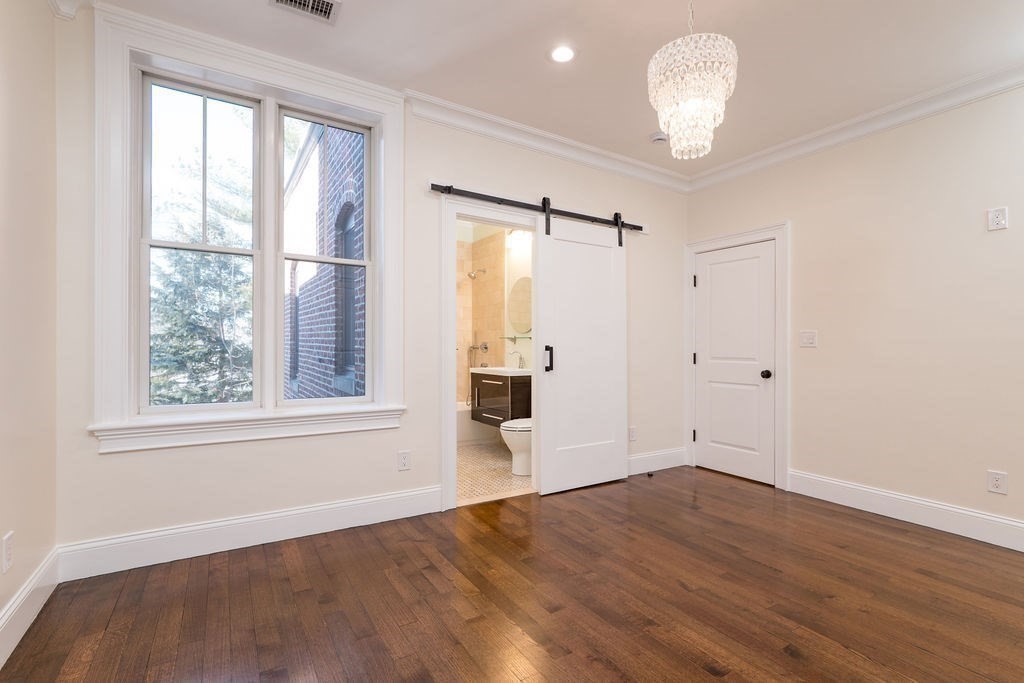 142 Fuller Street, Unit 4 Brookline, MA 02446 - Photo 24 of 40 an empty room with wooden floor and windows