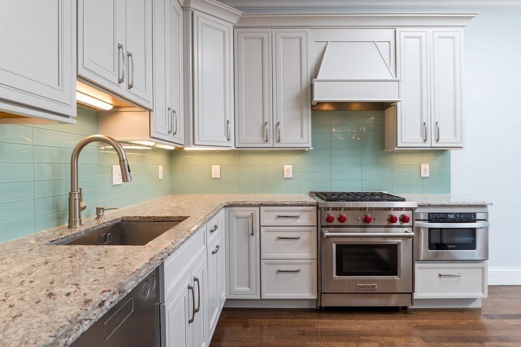 142 Fuller Street, Unit 4 Brookline, MA 02446 - Photo 4 of 40 a kitchen with granite countertop a sink a stove and cabinets