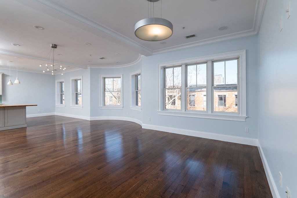 142 Fuller Street, Unit 4 Brookline, MA 02446 - Photo 5 of 40 a view of an empty room with window and wooden floor