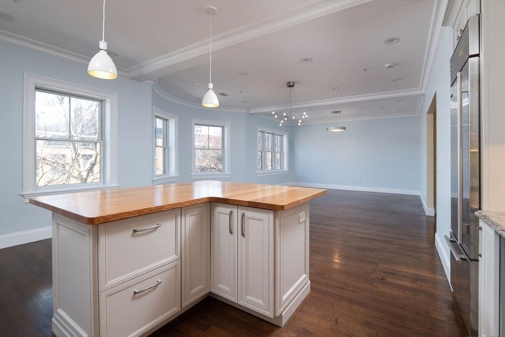 142 Fuller Street, Unit 4 Brookline, MA 02446 - Photo 7 of 40 a kitchen with granite countertop a sink and dishwasher with wooden floor