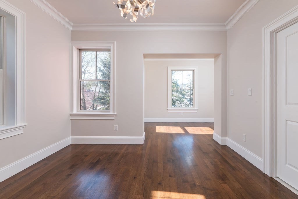 142 Fuller Street, Unit 4 Brookline, MA 02446 - Photo 9 of 40 a view of an empty room with wooden floor and a window