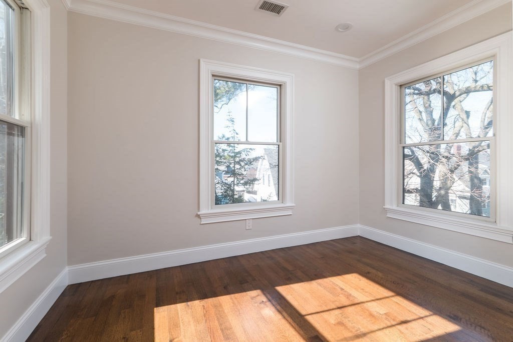 142 Fuller Street, Unit 4 Brookline, MA 02446 - Photo 10 of 40 an empty room with wooden floor and windows
