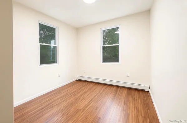 an empty room with wooden floor and a window