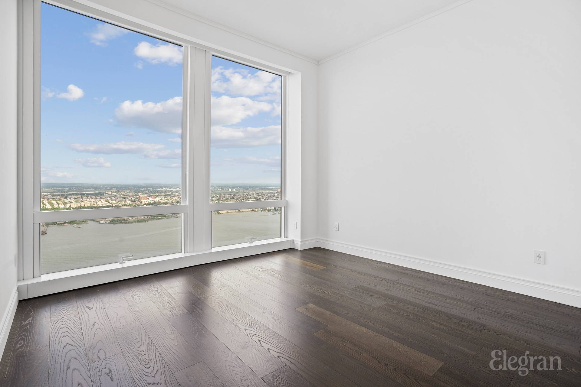 35 Hudson Yards, Unit 6901 Manhattan, NY 10001 - Photo 7 of 24 a view of an empty room with wooden floor and a window
