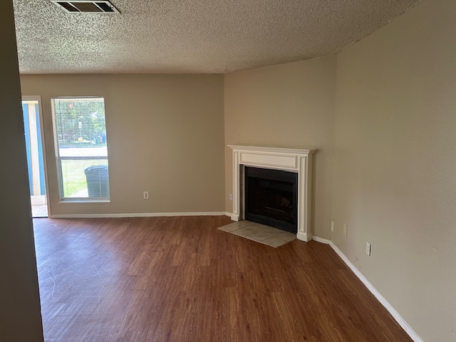 6912 Branchwood Drive, Unit B Austin, TX 78744 - Photo 2 of 11 an empty room with wooden floor a fireplace and windows