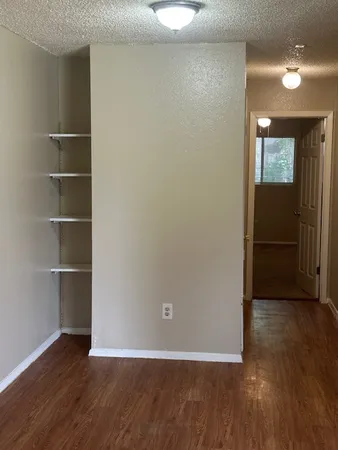 an empty room with wooden floor and closet