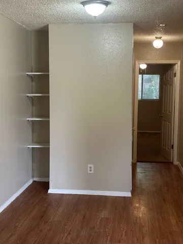an empty room with wooden floor and closet