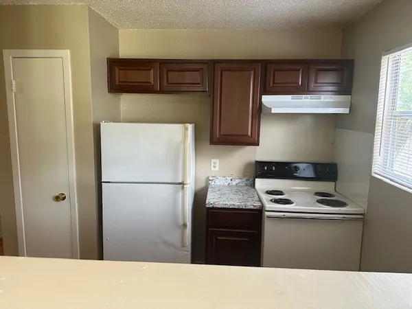 a kitchen with a refrigerator and a stove top oven