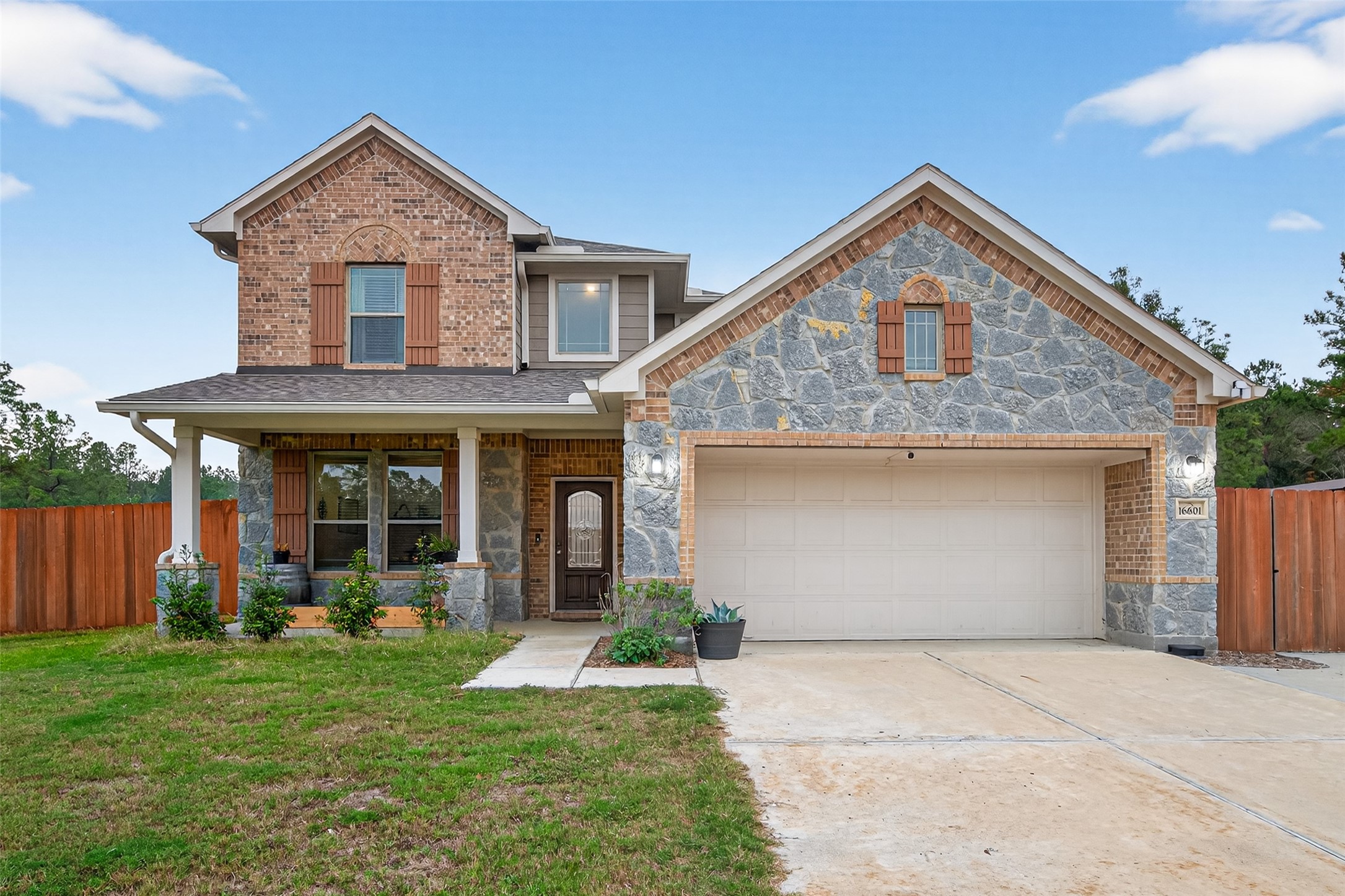 16601 Crosby Street Conroe, TX 77303 - Photo 1 of 50 Beautiful brick-and-stone elevation with charming shutters, a welcoming covered front porch, and a spacious two-car garage offering great curb appeal.