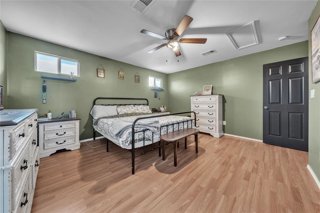100 Rosedale Avenue Keene, TX 76059 - Photo 11 of 22 Spacious room featuring wood-finish flooring, a ceiling fan with integrated lighting, and multiple windows providing natural light