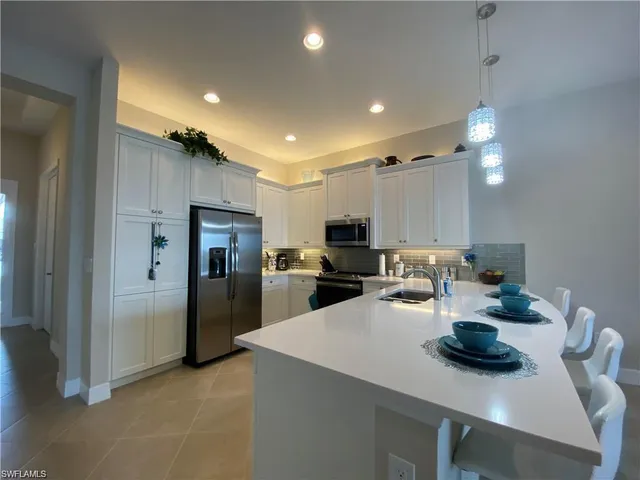 a kitchen with refrigerator and chairs