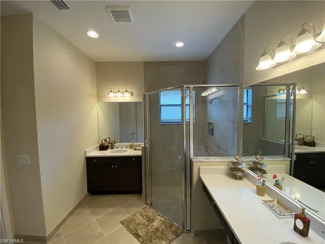 a bathroom with a double vanity sink mirror and shower