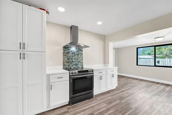 a kitchen with a stove and a wooden floors
