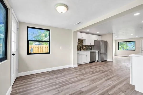 a view of a kitchen with wooden floor and a window