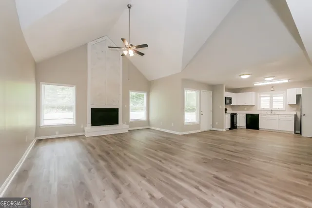 a view of empty room with wooden floor and fireplace