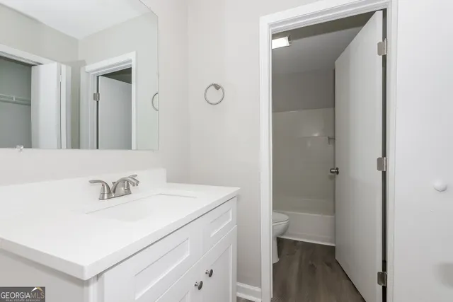 a bathroom with a sink a toilet and a mirror