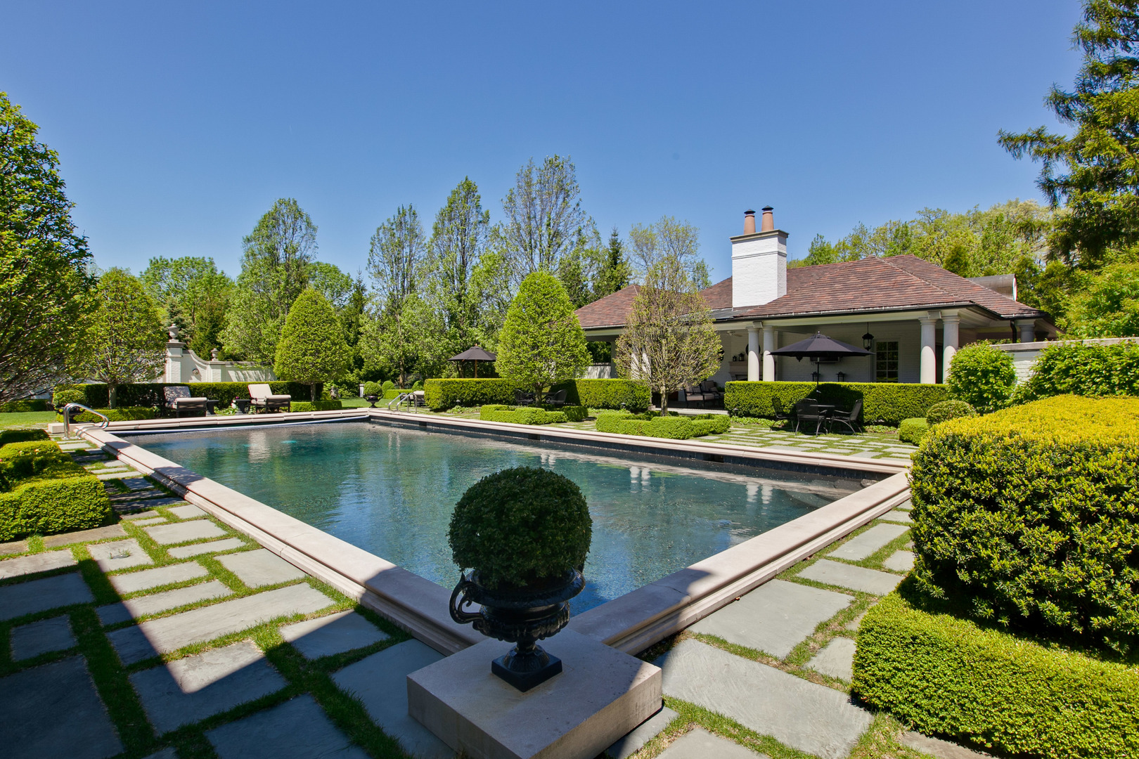 700 South Ridge Road Lake Forest, IL 60045 - Photo 32 of 47 a view of a swimming pool and lounge chairs in back yard of the house