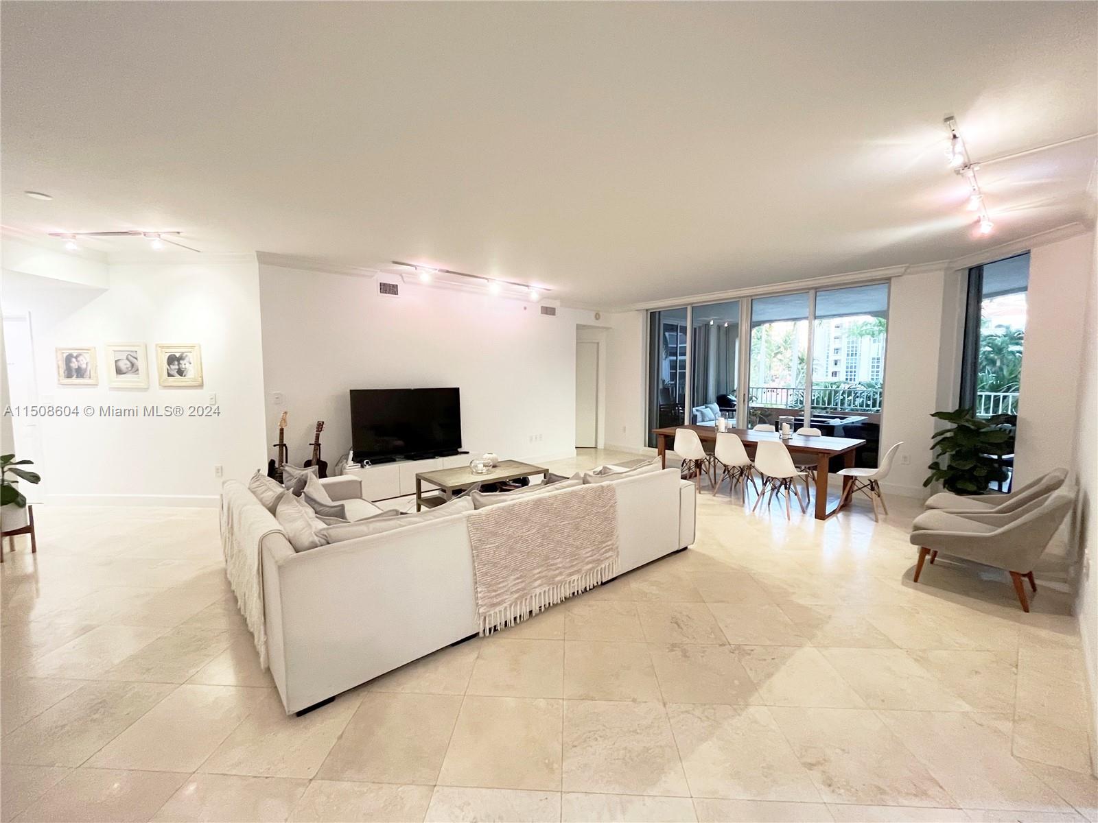 727 Crandon Boulevard, Unit 202 Key Biscayne, FL 33149 - Photo 23 of 32 a living room with furniture and a flat screen tv