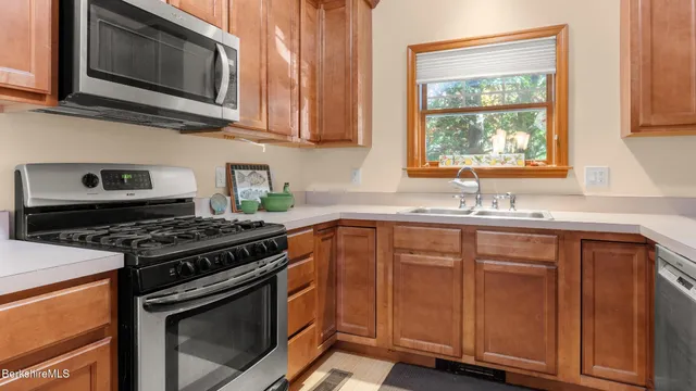 a kitchen with granite countertop wooden cabinets and a stove top oven