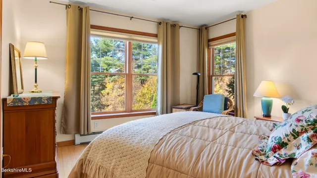 a bedroom with a bed and a dresser next to a window
