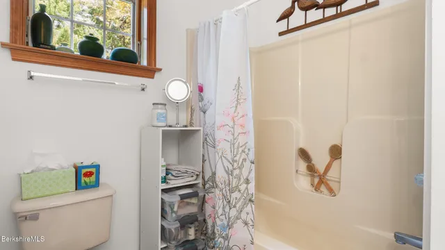 a bathroom with a shower curtain and a window