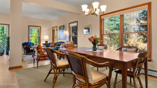 a dining room with furniture a chandelier and a large window