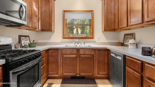 a kitchen with granite countertop a sink stove and cabinets