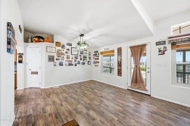 a view of an empty room with window and wooden floor