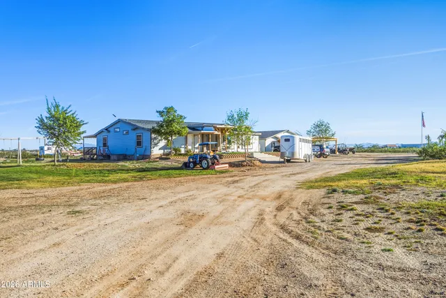 a view of a swimming pool with a yard and palm trees