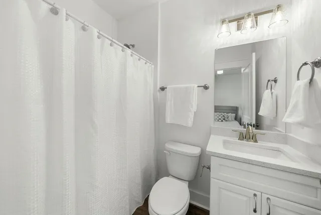 a bathroom with a toilet a sink and a mirror