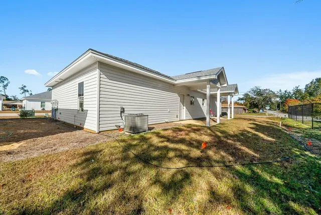 a view of a house with backyard and trees