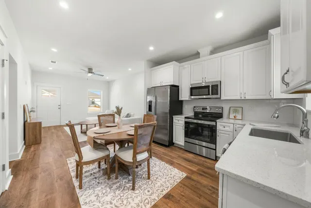 a kitchen with microwave a stove a table and chairs
