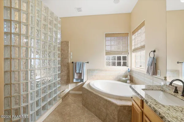 a bathroom with a granite countertop sink a mirror and a shower