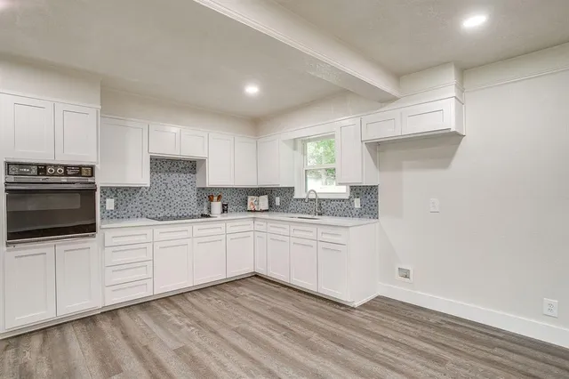 a large kitchen with kitchen island granite countertop wooden cabinets and white appliances
