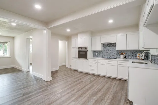 a view of an empty room with wooden floor and closet