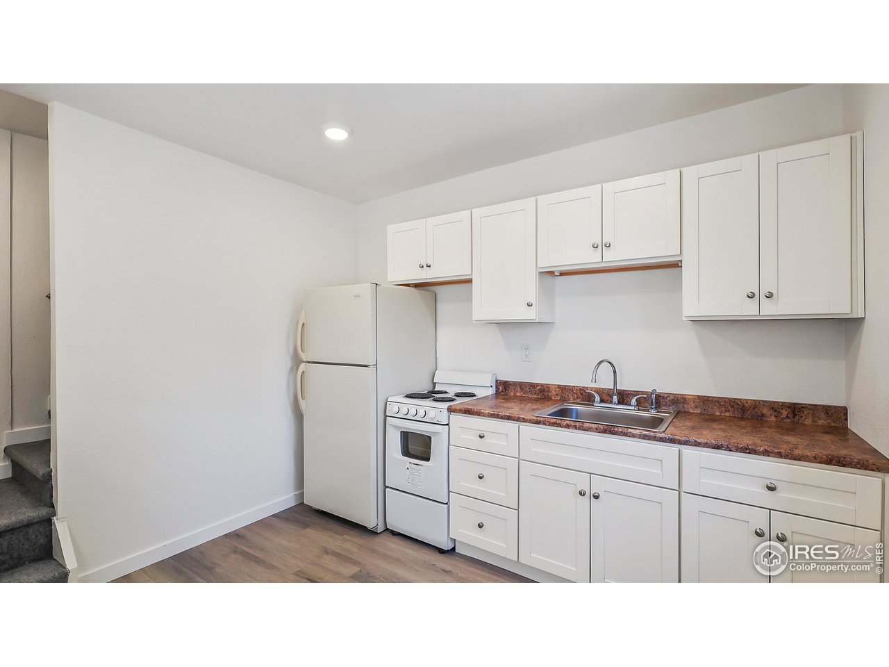 1408 Edison Street Brush, CO 80723 - Photo 15 of 23 a kitchen with white cabinets and white appliances