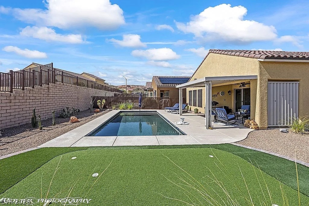 1304 Cottage Ridge Mesquite, NV 89034 - Photo 4 of 52 A private backyard oasis features a shimmering pool, putting green, and covered patio for year-round enjoyment.