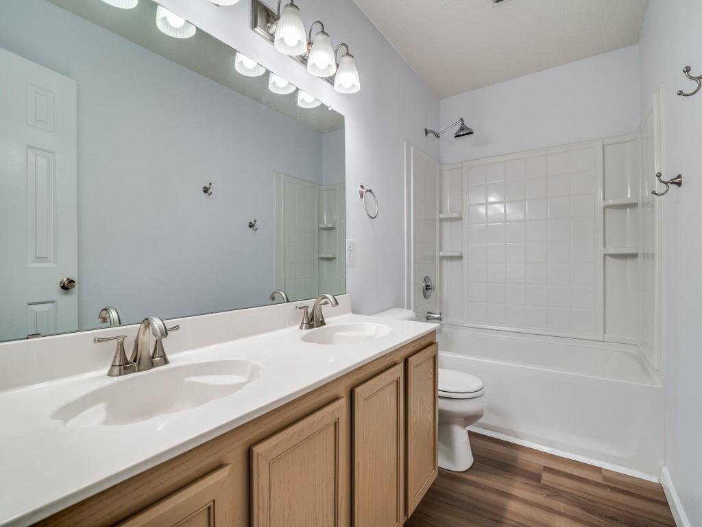 3100 Misty Ridge Lane Rockwall, TX 75032 - Photo 13 of 25 a bathroom with a sink a toilet a mirror and shower