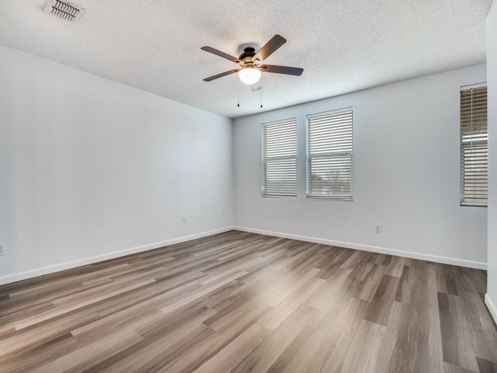 3100 Misty Ridge Lane Rockwall, TX 75032 - Photo 18 of 25 an empty room with wooden floor chandelier fan and windows