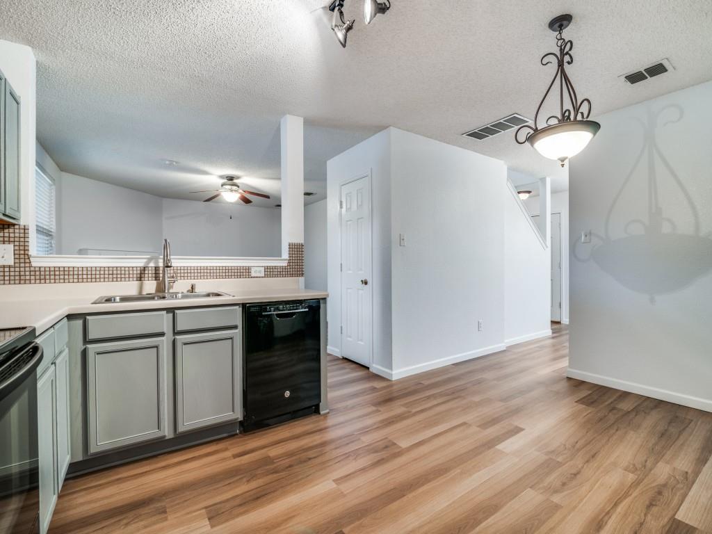 3100 Misty Ridge Lane Rockwall, TX 75032 - Photo 4 of 25 a kitchen with stainless steel appliances granite countertop a sink cabinets and wooden floor