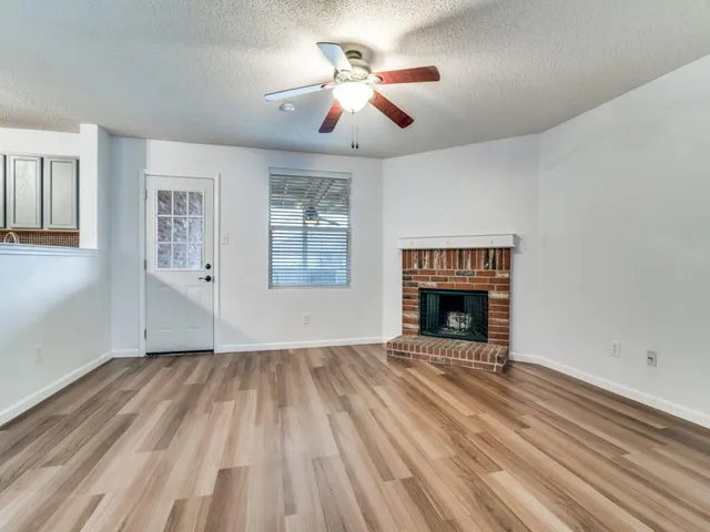 a view of an empty room with a fireplace and a window