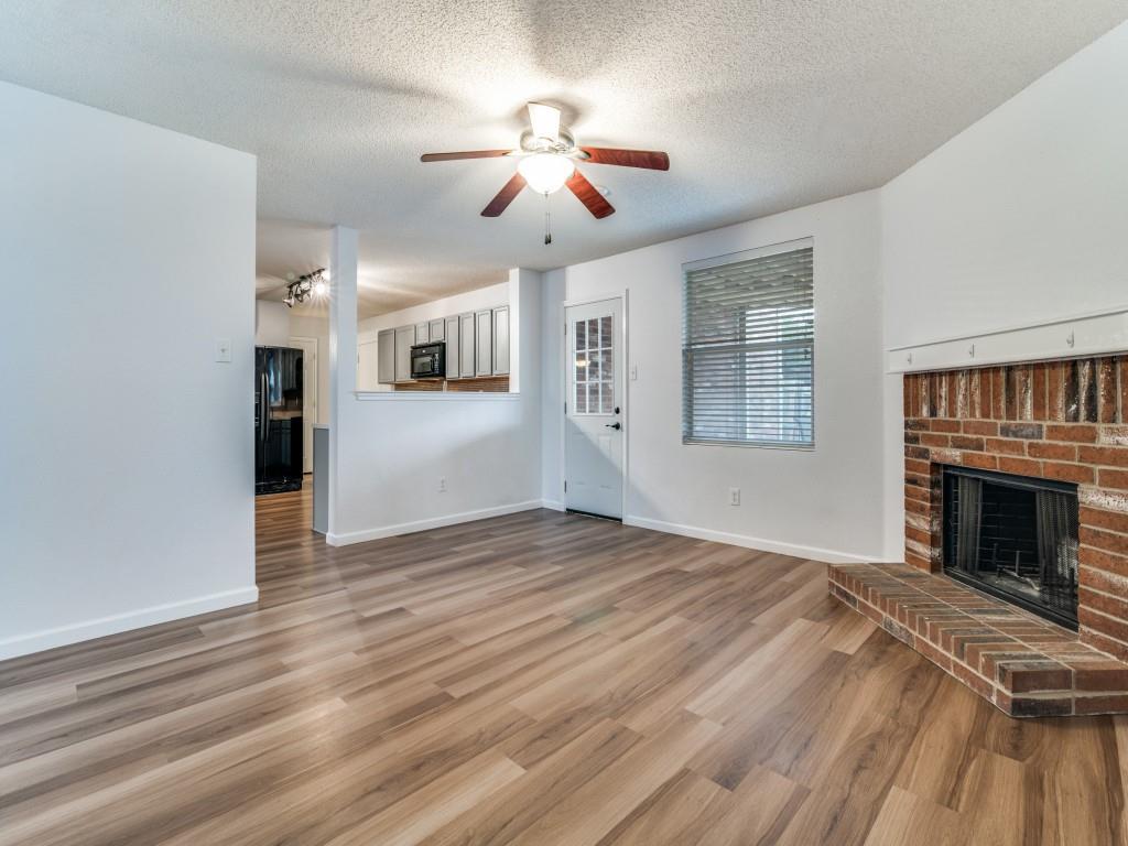 3100 Misty Ridge Lane Rockwall, TX 75032 - Photo 9 of 25 a view of an empty room with wooden floor fireplace and a window