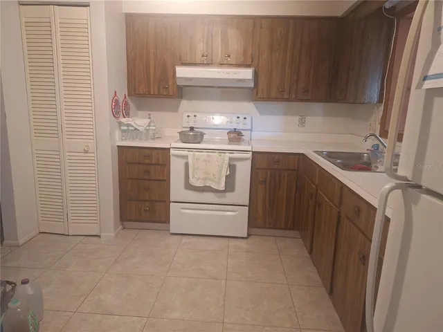 a kitchen with a stove sink and cabinets
