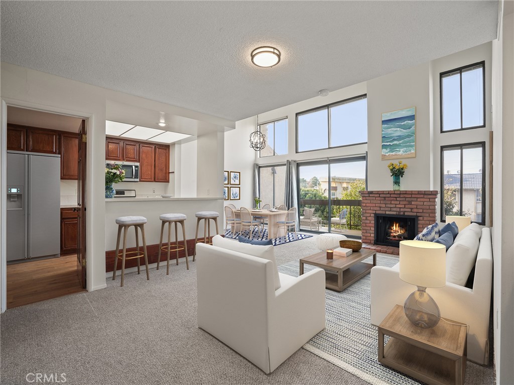 a living room with furniture a fireplace and a large window